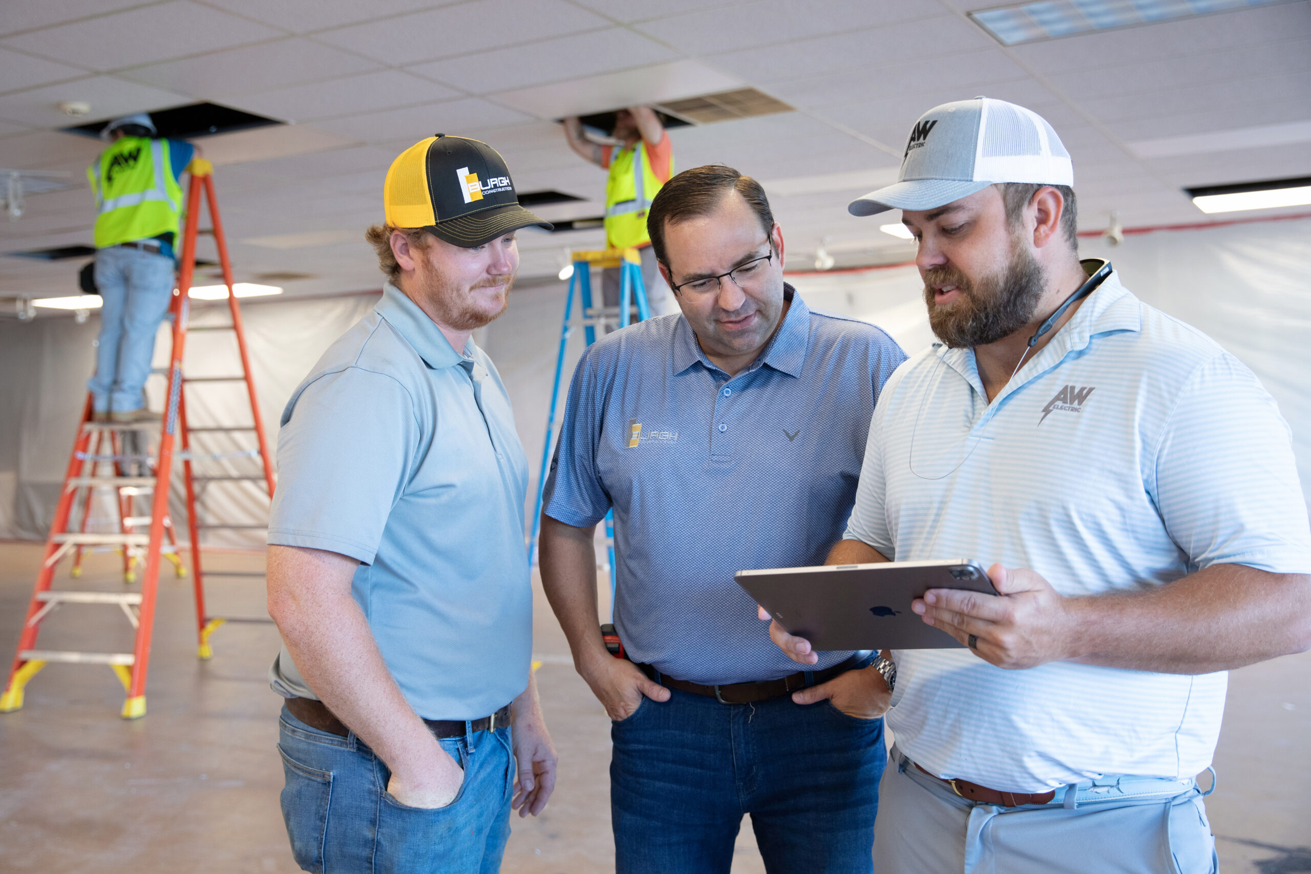 Workers review a tablet on site.