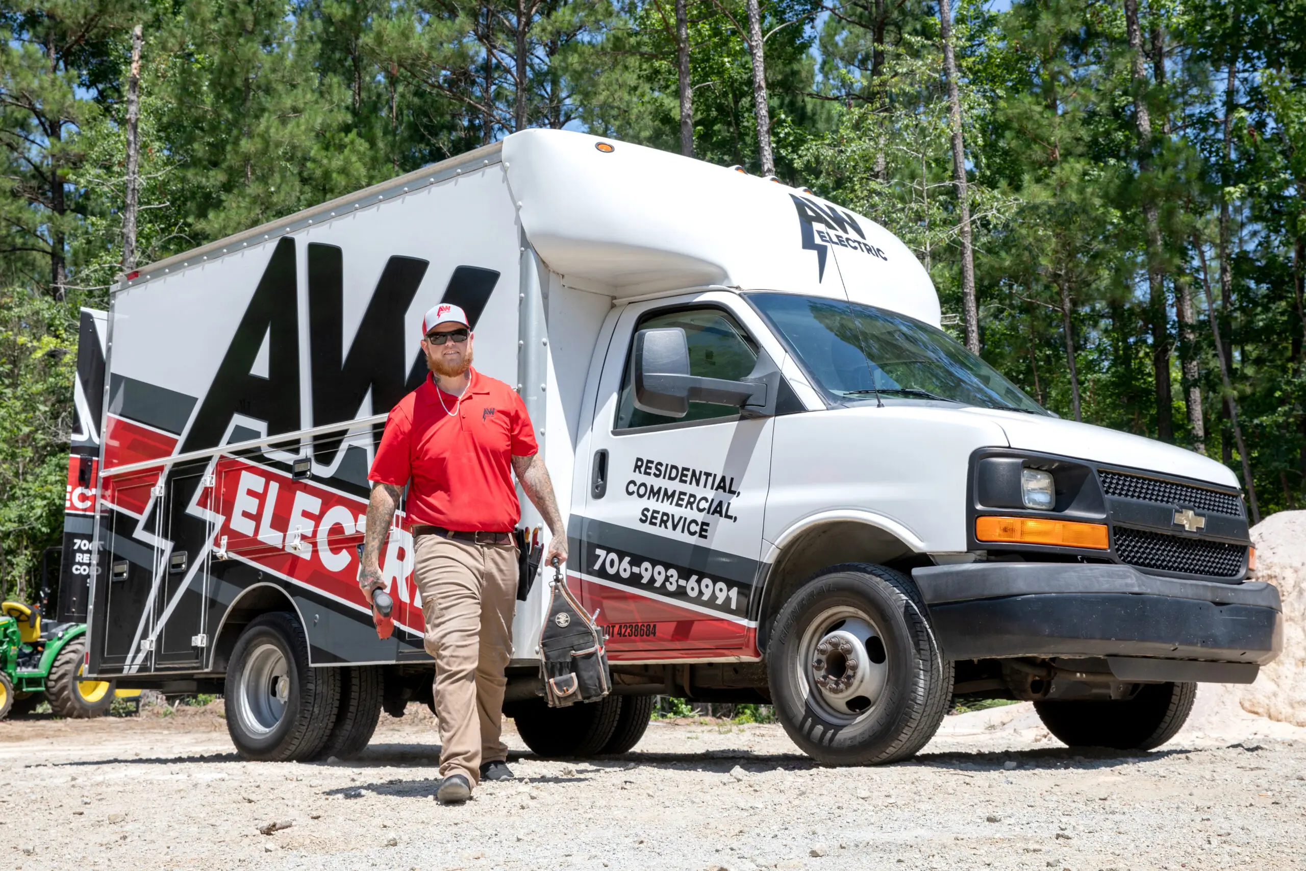 man in red walks from an AW Electric service truck